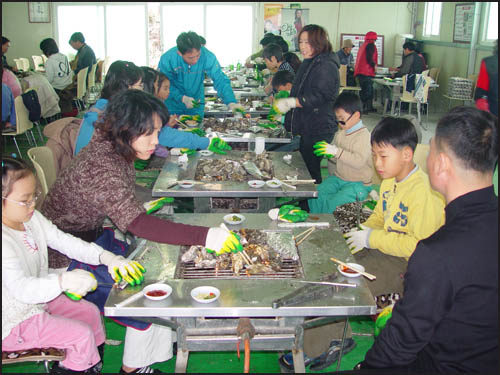 옹기종기 모여 앉아 굴을 까먹고 있다. 